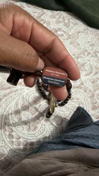 Cliente segurando detalhe das placas dos mistérios na cama